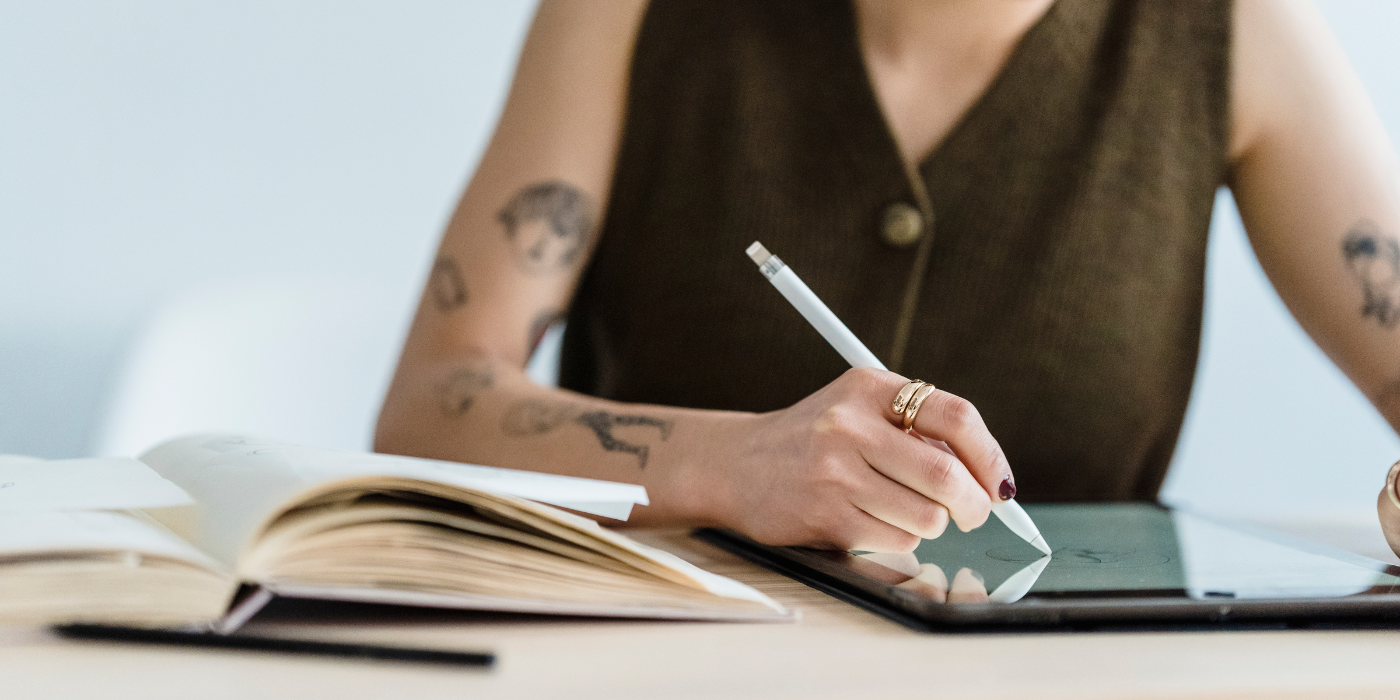 Coworker che lavora a un progetto editoriale digitale su tablet, tra grafica e ebook, nello spazio di coworking Officina Scrittoria a Peschiera Borromeo.